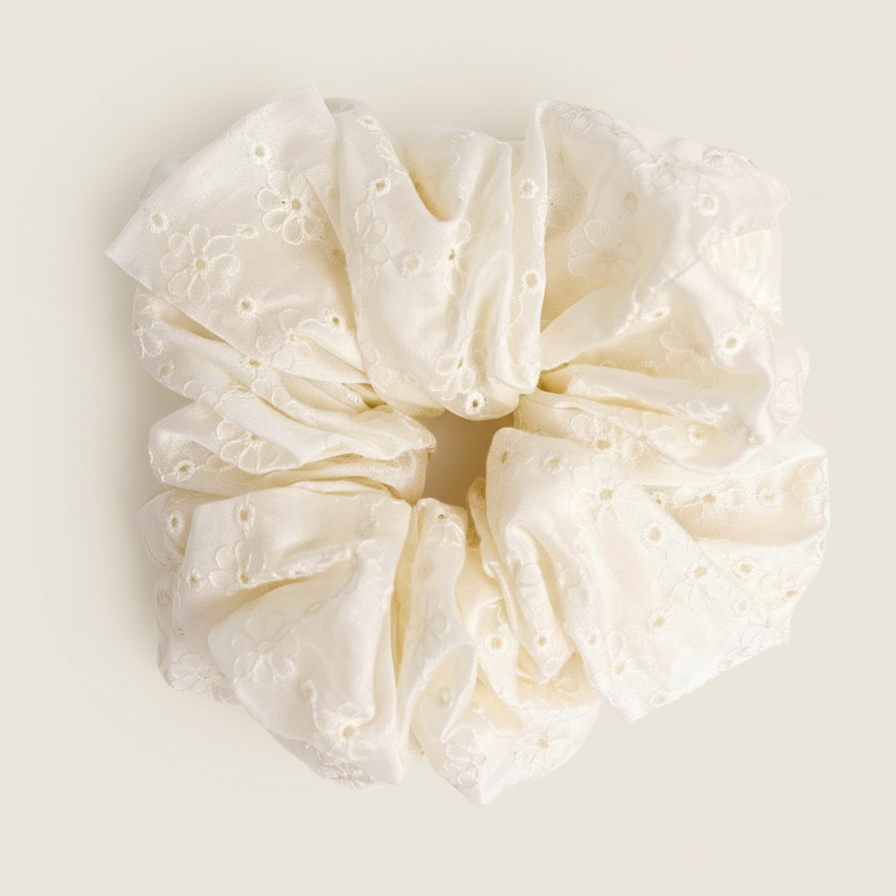 Cream-colored lace scrunchie on a light beige background